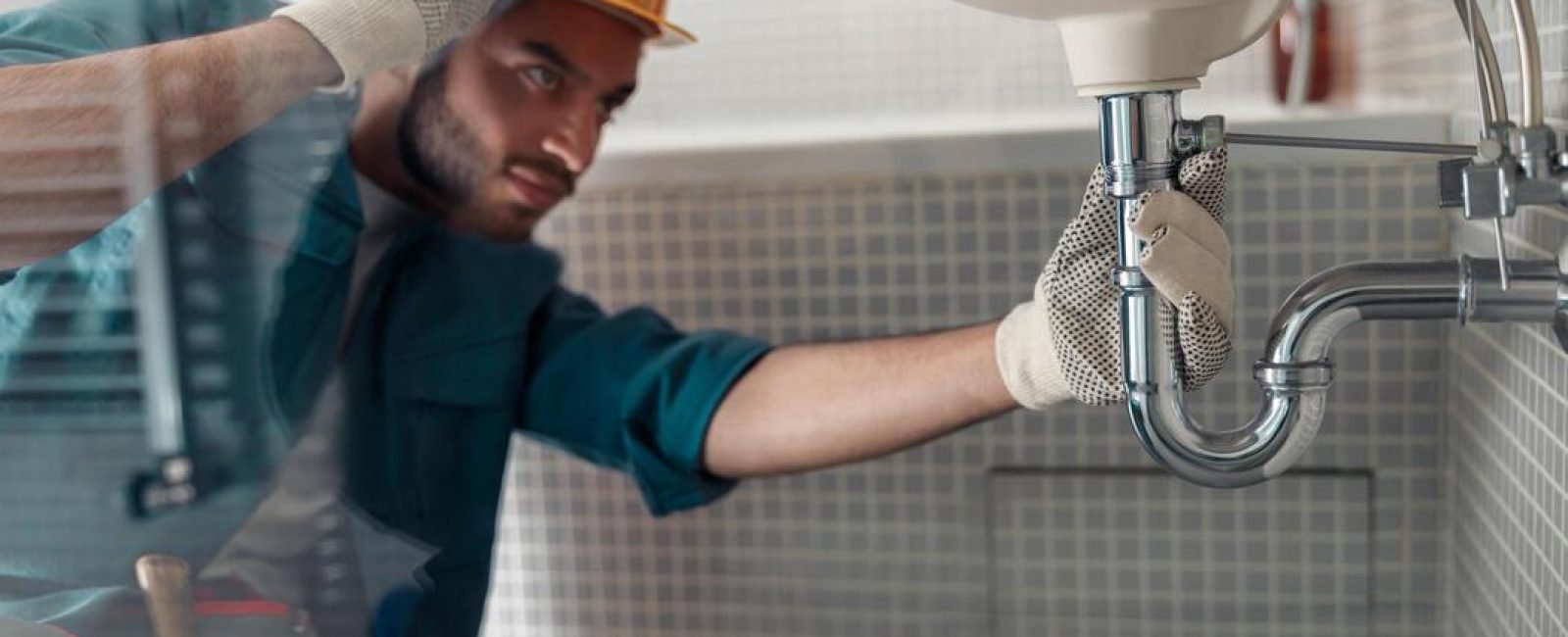 male-plumber-is-repairing-faucet-of-a-sink-at-bathroom-good-quality-plumbing-company-service-photo